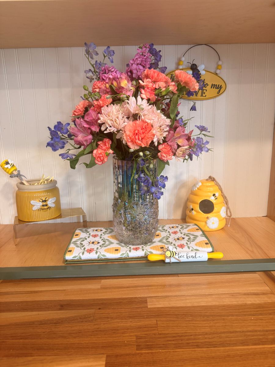 Coral and purple arrangement with bee decor