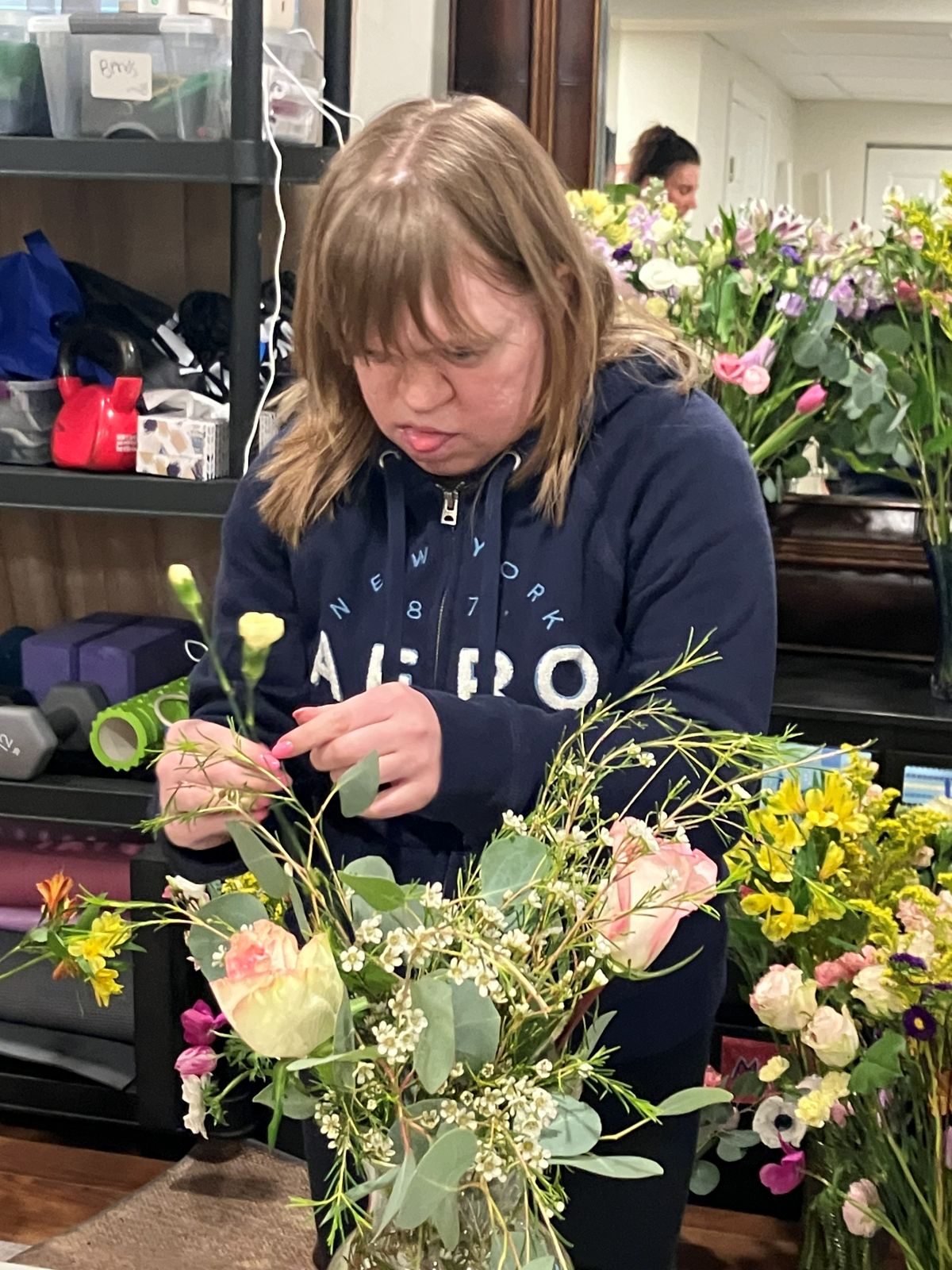 A team member building an arrangement in a blue vase