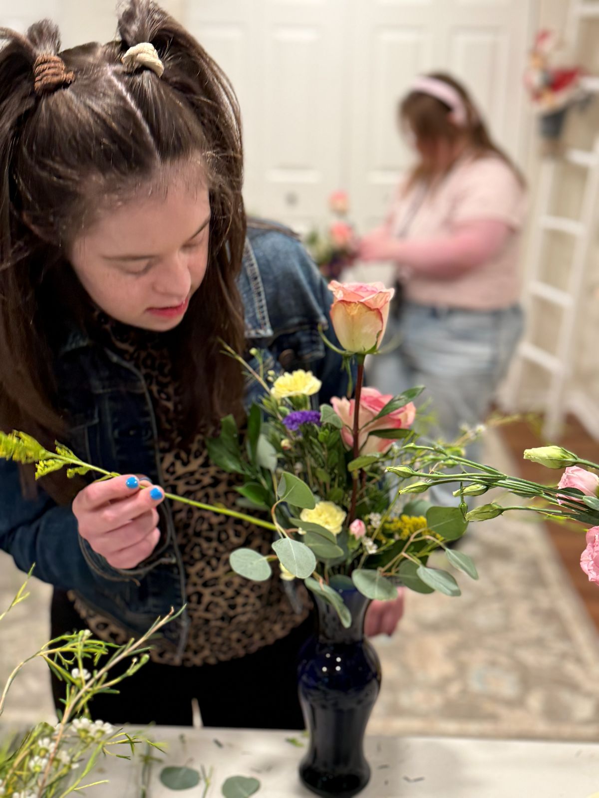 A team member carefully placing flowers into a vase