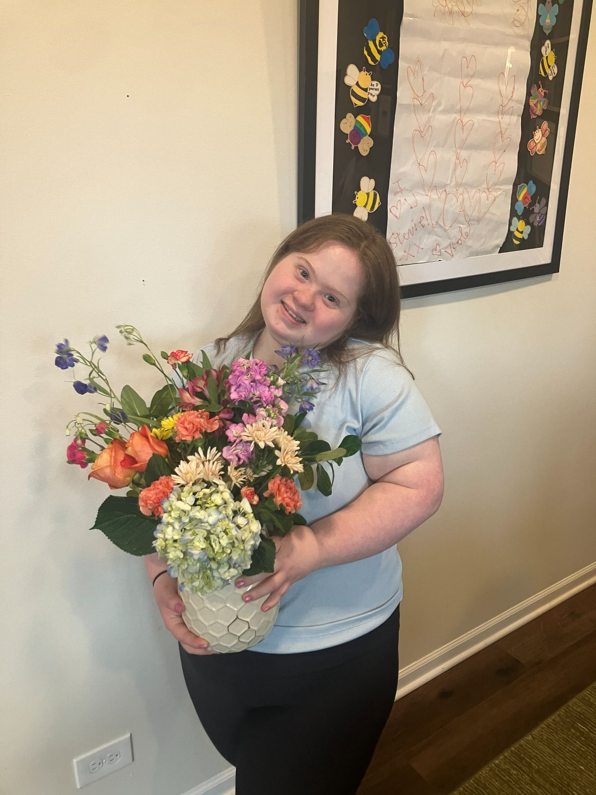 A team member holding up her finished arrangement