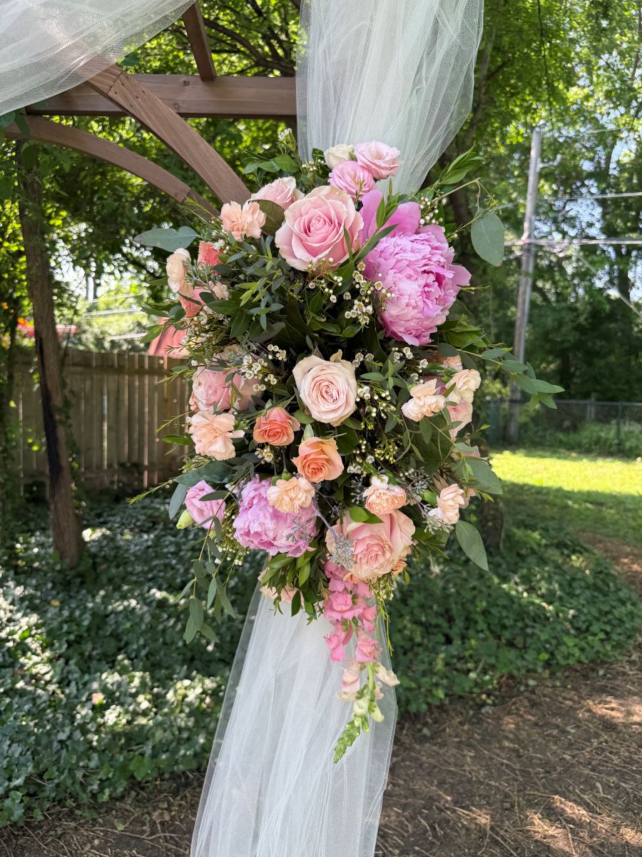 Pink rose and peony floral piece on a ceremony arch